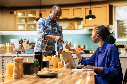 Foto African american partners make a grocery list and compare goods, ordering food and perishable items by shopping online using a laptop in their kitchen