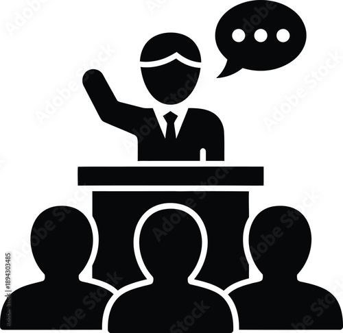 A person in a suit speaking at a podium to an audience