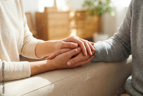 Close-up of couple holding hands during emotional conversation at home