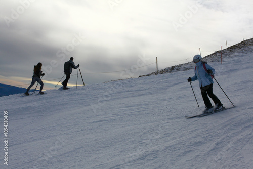 Skiers Going Down a Snowy Slope at Ski Resort in Winter