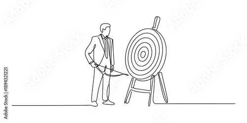 A focused businessman standing with bow and arrow next to a large target board
