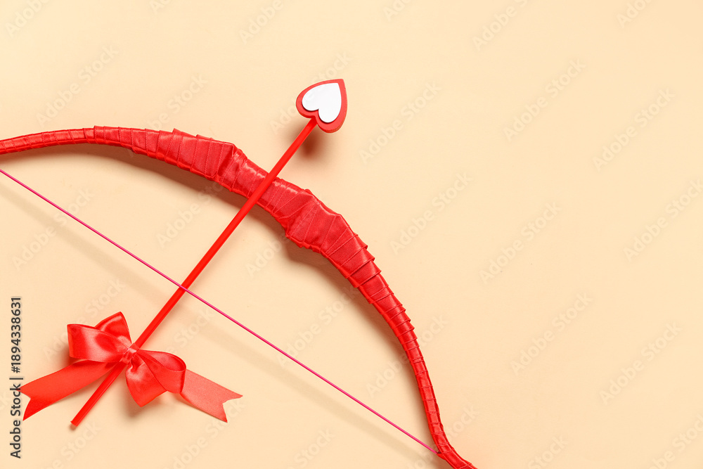Obraz premium Red cupid's bow on color background. Valentine's Day celebration