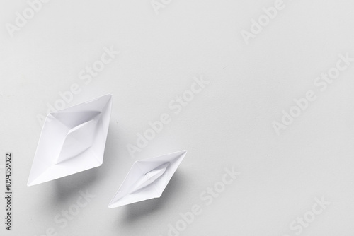 White paper boats on grey b...