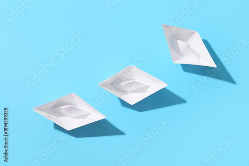 White paper boats on blue b...