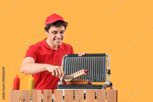 Male worker grilling hot do...
