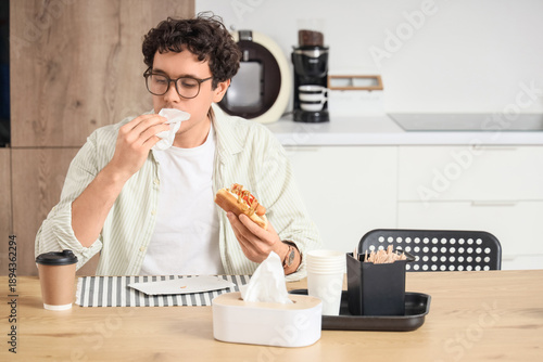 Young man with tissue eatin...
