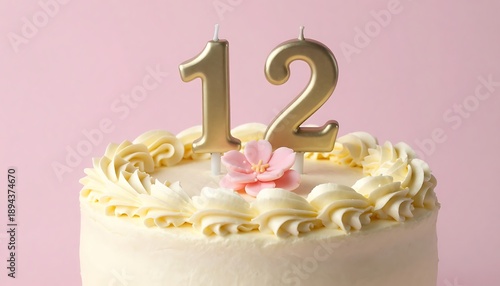 A festive vanilla cake celebrating a twelfth birthday with elegant golden number candles and a delicate pink flower