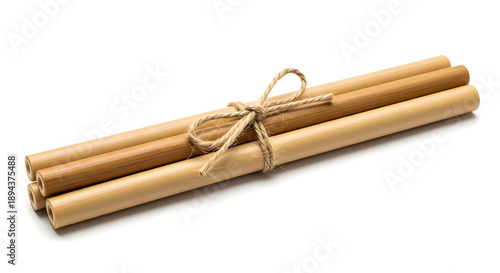 A bundle of natural bamboo drinking straws tied with a rustic string, isolated on a white background, promoting eco-friendly living.