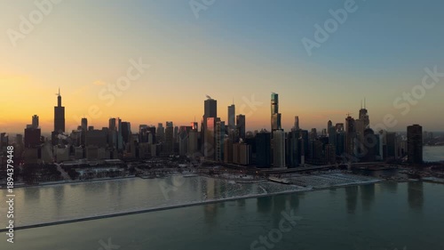 Wallpaper Mural Drone view of downtown Chicago skyline at sunset at winter. Ice formations float on the surface of Lake Michigan as subzero temperatures create frozen patterns along the shoreline Torontodigital.ca