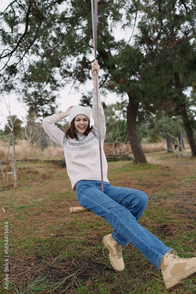 Obraz premium joyful swing scene in outdoor park, girl in casual clothing smiles as she swings, graceful playful moment among trees and open space, fresh air and sunlight, candid outdoor leisure