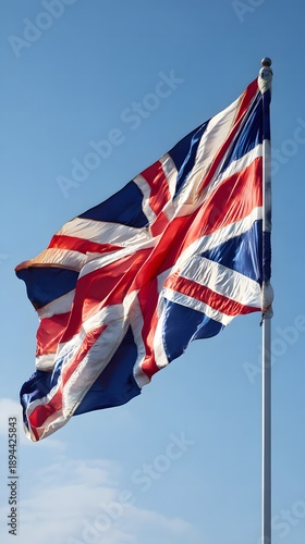 Wallpaper Mural A vibrant British national flag, featuring the iconic red, white, and blue design, proudly waves against a clear azure sky, symbolizing unity and heritage and the spirit of the nation Torontodigital.ca