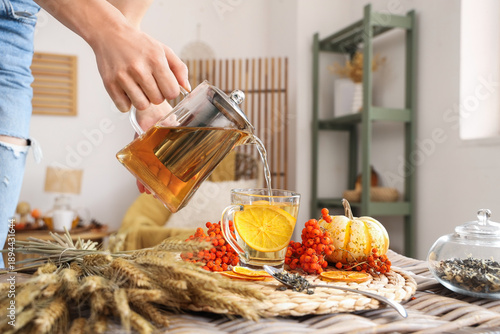 Female hand pouring tea fro...