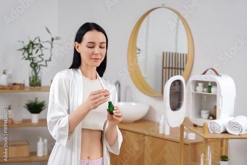 Young woman with serum near...