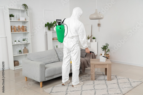 Male worker with disinfecta...
