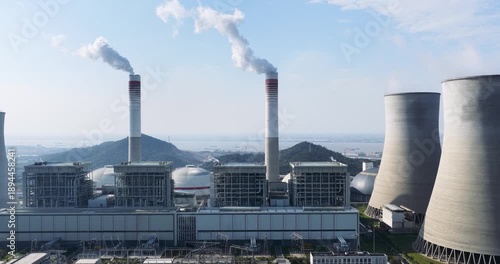 Wallpaper Mural Aerial drone footage panning left across a modern coal-fired power plant: cooling towers, smokestacks emitting steam, and industrial buildings under clear blue sky. Torontodigital.ca