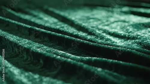 Close-up of luxurious emerald green velvet fabric with soft folds and textures.