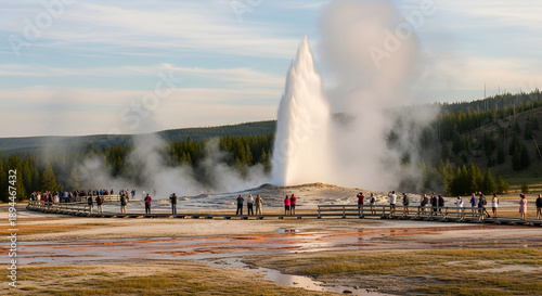 Wallpaper Mural Tourists gather along a wooden boardwalk to witness the spectacular eruption of a towering natural geyser amidst steam and distant forests Torontodigital.ca