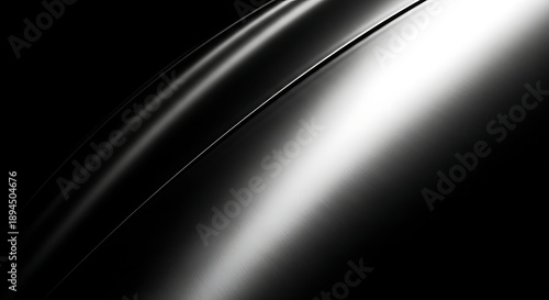 Close up of a sleek curved metallic surface reflecting light with a dramatic black background
