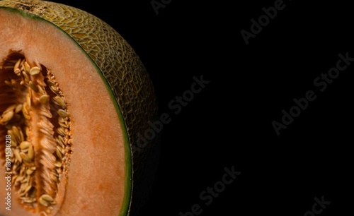 Fresh cantaloupe melon slice on a black background