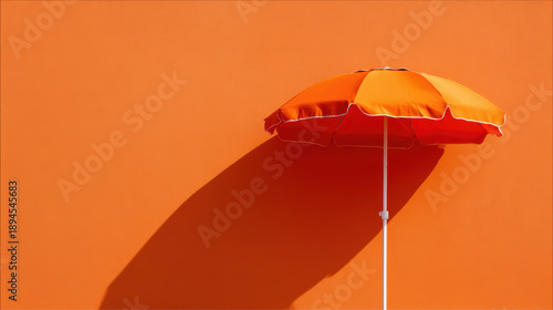 Orange umbrella beach umbrella wall shadow summer minimal sunshade outdoor vacation travel bright orange beach umbrella against orange wall