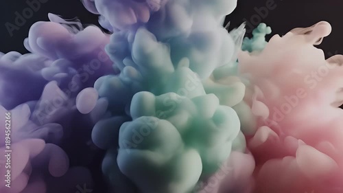 Colorful ink clouds swirling and mixing abstractly against a dark background.