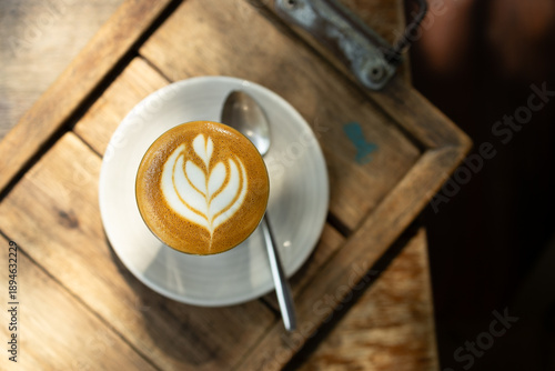 Cup of coffee latte art on wood table.