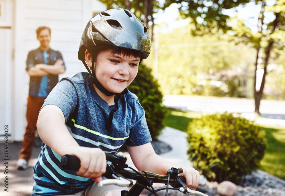 Obraz premium Neighborhood, happy and dad with boy on bicycle for cycling, learning to ride and exercise. Family home, holiday and father watching kid on bike for development, hobby and outdoor activity on weekend