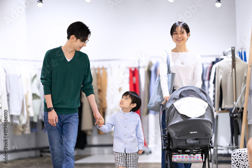 ブティックでベビーカーを押しながら歩く家族
