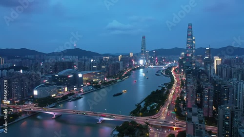 Wallpaper Mural Ultra-wide aerial drone video of a modern metropolis at twilight. Illuminated skyscrapers, winding river reflecting city lights, vibrant red and white light trails from cars, subtle boat trails on Torontodigital.ca
