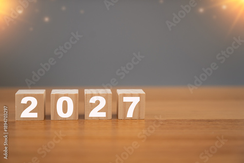 Wooden cubes displaying 2027 on a table with sunlight background, representing future planning, new year goals, business vision, and upcoming opportunities.