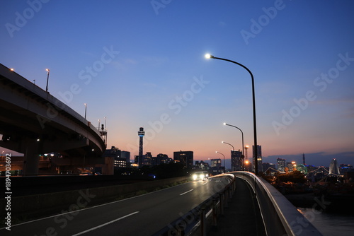 Canvastavla 日没直後　オレンジ色に染まる空と横浜の新山下付近の車道とみなとみらいのシルエットと車道