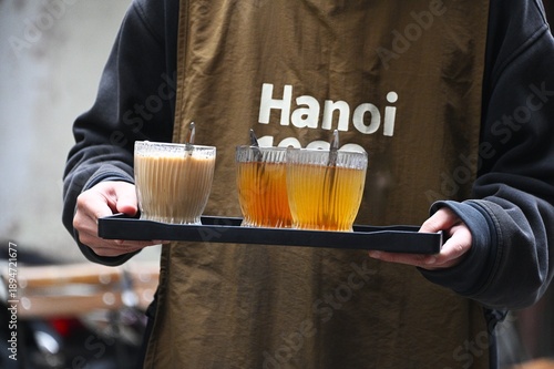 Vietnamese Server Holding Tray of Tea and Coffee Glasses at Hanoi Cafe, Vietnam