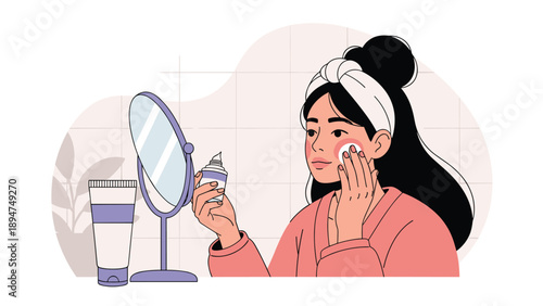Young woman with a headband applying skincare cream to her face while looking in a round mirror in the bathroom.