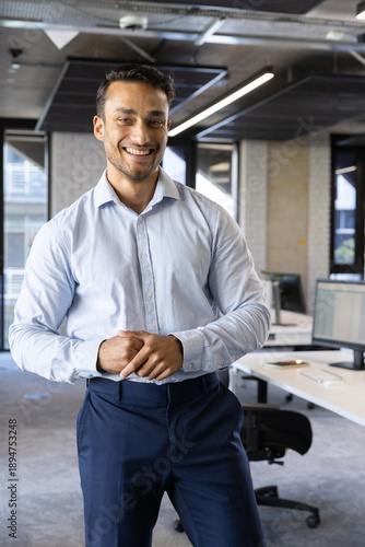 Wallpaper Mural South asian man standing in business attire in open plan office with computer monitors Torontodigital.ca