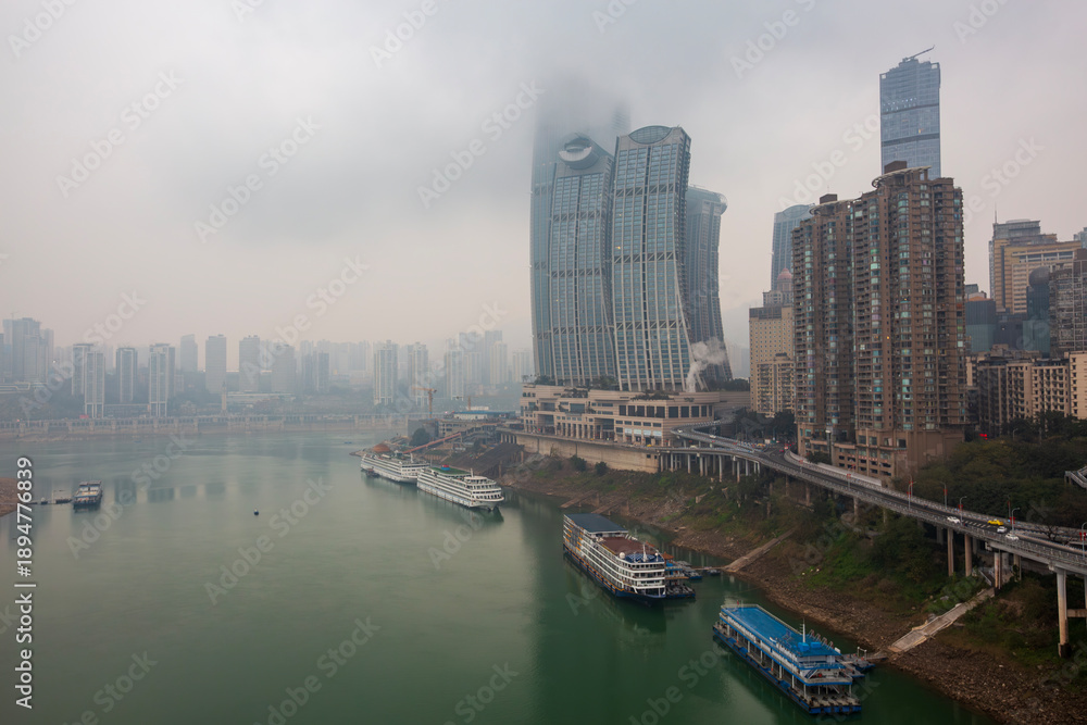 Fototapeta premium City terrain and architectural landscape along the riverside in fog, Chongqing, China