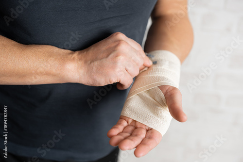 Man's hand wrapping elastic bandage