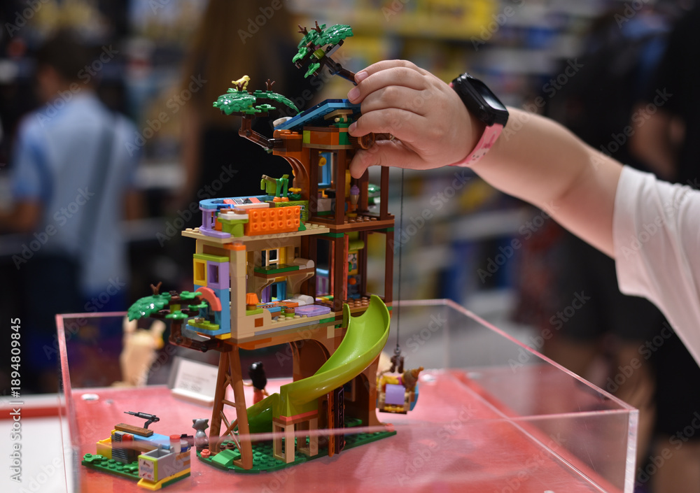 Obraz premium The child is playing with a Lego house