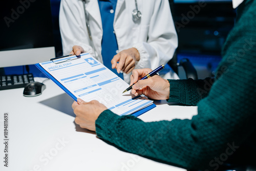Fotografie Doctor explains medical form as patient signs consent in modern clinic