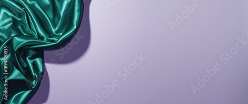 Photograph of a shiny green textile surface contrasted with a muted purple silk backdrop