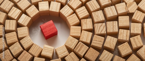Isolated red wood block in a circular arrangement of wooden cubes, representing uniqueness and standout qualities