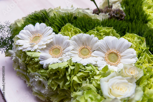 Fotografía Witte bloemen in een rouwboeket op een kist tijdens een uitvaart