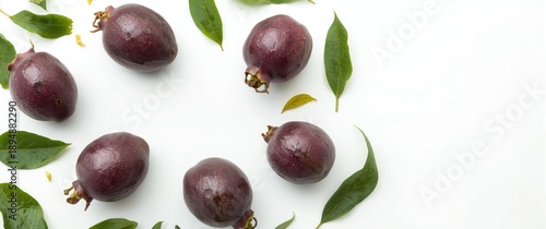 Arrangement of recently ripened passion fruits (maracuyas) with leaves on a white surface