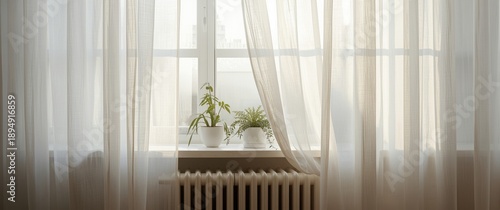 Modern room featuring translucent white curtains hanging above radiator and window sill, allowing light to flow in