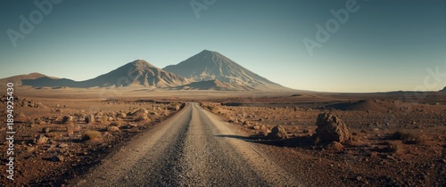 Majestic desert landscape featuring a gravel road leading to impressive mountains beneath a clear sky. Suitable for travel, adventure, and nature themes. Volcano Teide area. Tenerife. Canary Islands