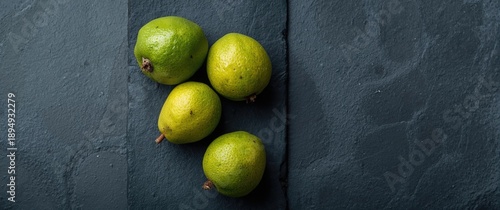 Obraz  z motywem Top view of several sweet and fragrant feijoa fruits on a slate surface