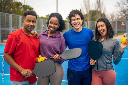 Diverse friends enjoying pickleball on blue court