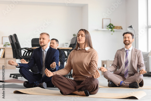 Group of business people meditating in office