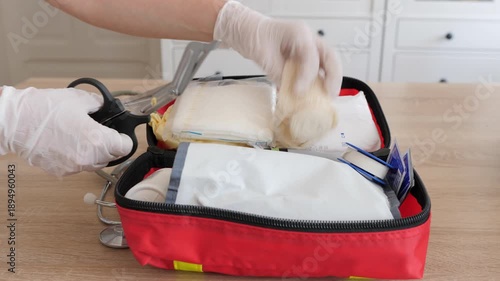 First aid kit in use. Scissors are cutting adhesive tape