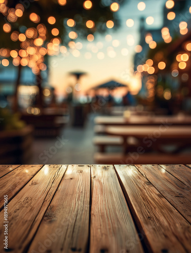 Wooden table surface in a vibrant outdoor setting, illuminated by warm string lights, creating a cozy atmosphere for gatherings and social events during sunset