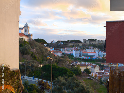 The Castelo de Sao Jorge or St George's Castle on its hill overlooking the city of Lisbon, Portugal. View from viewpoint Miradouro da Senhora do Monte before sunset.